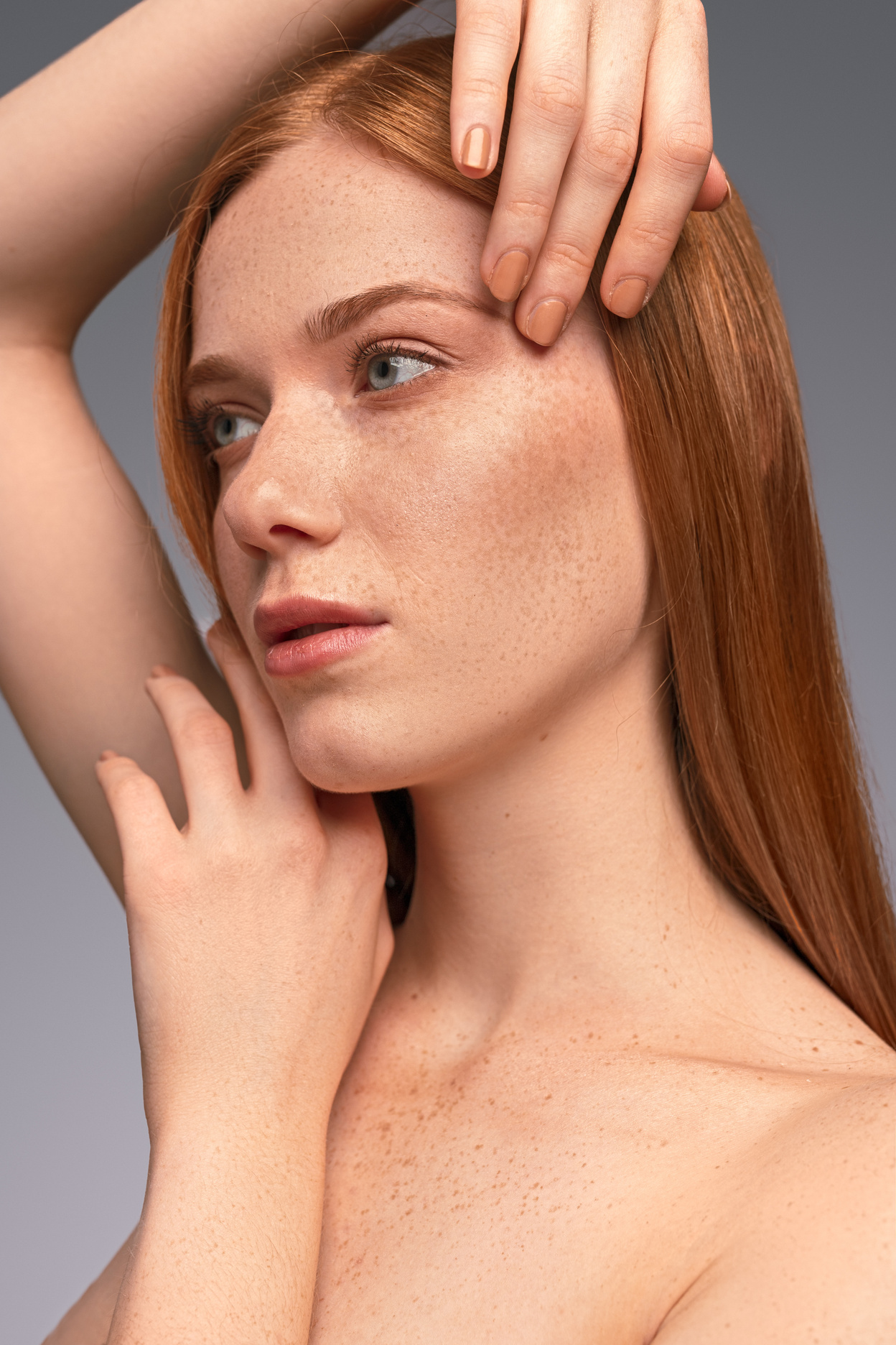 Freckled woman touching clean face